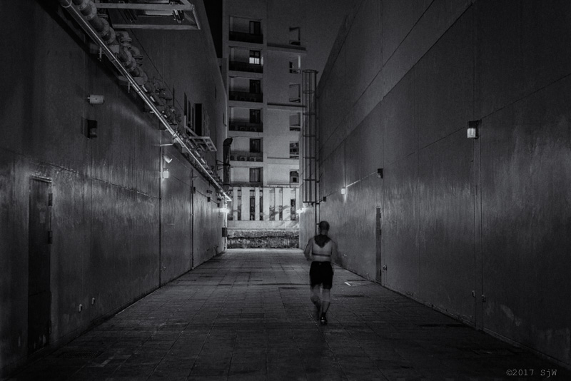 Man running in an alley at night