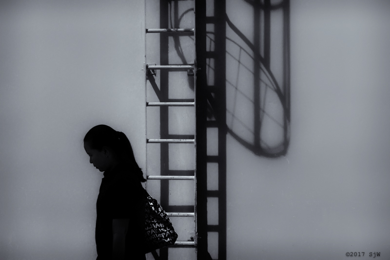 Woman walking in front of a fire-escape in Bangkok