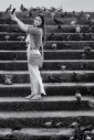 Young woman with mobile phone on the riverside steps of Wat Rakhang in Bangkok