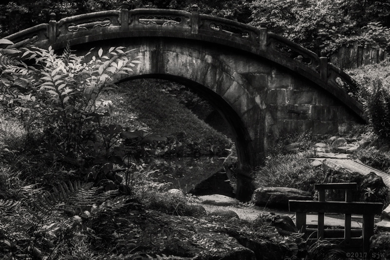 Stone bridge over a stream in Koishikawa Korakuen Garden