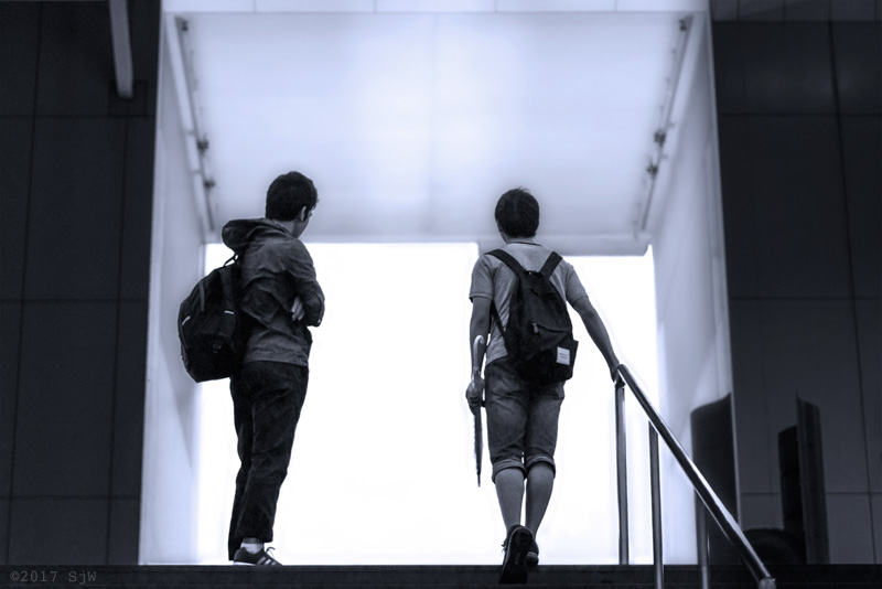 Young men waiting at the top of the stairs at Kyoto Station