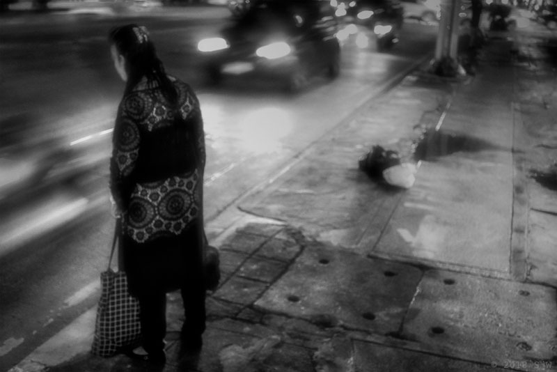 Woman waiting by the kerbside in Bangkok